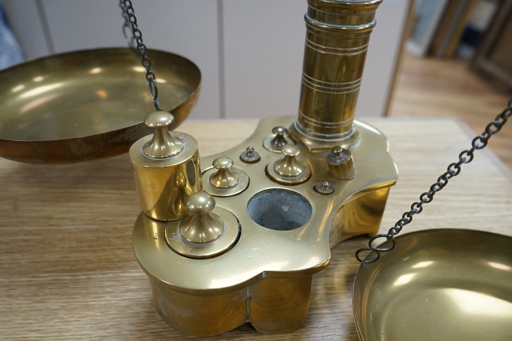 A pair of brass beam scales with decorative bull's head finial and weights, 56cm high
